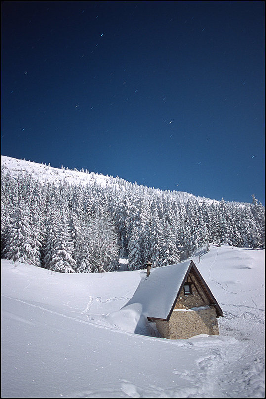 Rcits de randonnes : GR bien dam, impossible de se perdre. Raquettes inutiles jusqu' la cabane, atteinte vers 3h. Marcher rchauffe, heureusement...Il fait dcidment
 bien froid cette nuit. La lune qui illumine tout le paysage, les troues dans
 les arbres qui laissent apercevoir les Moucherolles, la Tte des Chaudires, les
 rochers de la Balme, remplissent les yeux. Tout est calme cette nuit.
 
  Sance th-chocolat chaud devant la cabane de Carette, avec quelques photos de
 nuit : je n'aurais pas port les 3kg du trpied photo pour rien...C'est ici que
 s'arrtent les traces : la prairie de Carette a t un peu parcourue, le GR
 continue bien balis, mais on ne devine la sente qui monte vers le pas Ernadant
 qu' l'aide d'une trs ancienne trace  peine visible. Raquettes au pied, la
 randonne commence vraiment ici. 
 
  La lune pleine facilite beaucoup l'orientation, le paysage devient familier 
 force d'y venir, et sans jamais tre tout  fait sr d'tre sur la bonne 
 route, je suis quand mme rapidement optimiste aprs le dpart de Carette. 
 D'autant plus que le GPS au fond du sac pourra nous aider en cas de problme. 
 
