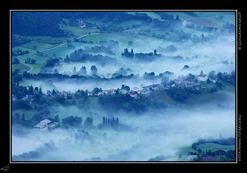 Photo : Les brumes sur le village de Roissard, dans le Trives, dessinent les silhouettes des haies et des habitations. 
