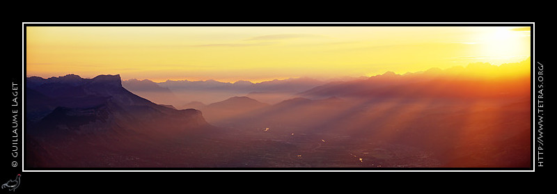 Photo : Un lever de soleil au dessus de Belledonne, depuis le Vercors : les rayons du soleil et l'ombre des sommets se rfltent sur les brumes de valle.. 
