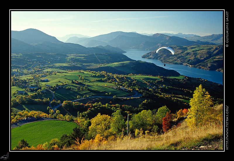 Alpes du Sud : Parapentiste en vol au dessus de Saint-Vincent-les-Forts et du lac de Serre-Ponon